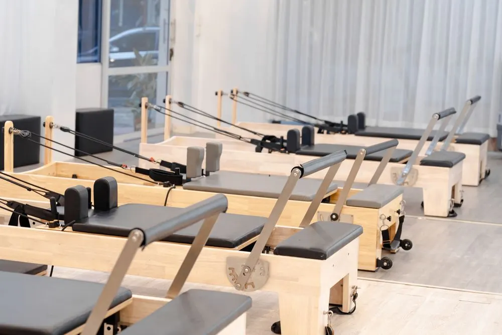 Wooden reformers in a light-filled pilates studio